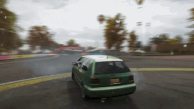 a green car with a new york license plate is driving on a wet road