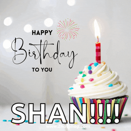 a cupcake with a lit candle and the name shan on it