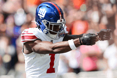 a new york giants football player wearing a blue helmet