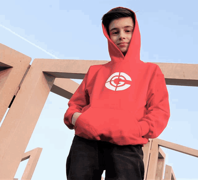 a boy wearing a red hoodie with a target on the front