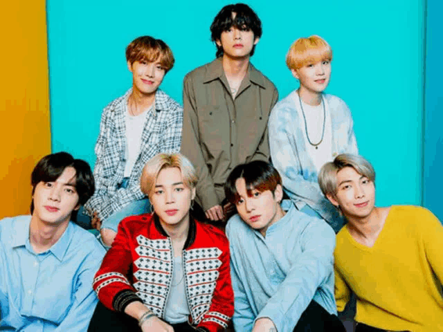 a group of young men are posing for a picture in front of a blue background