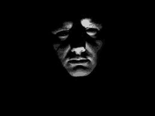 a black and white photo of a man 's face in the dark