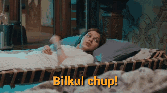 a woman is laying on a bed with the words bilkul chup written on the bottom