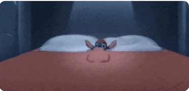 a cartoon character is laying on a bed with pillows and a blanket