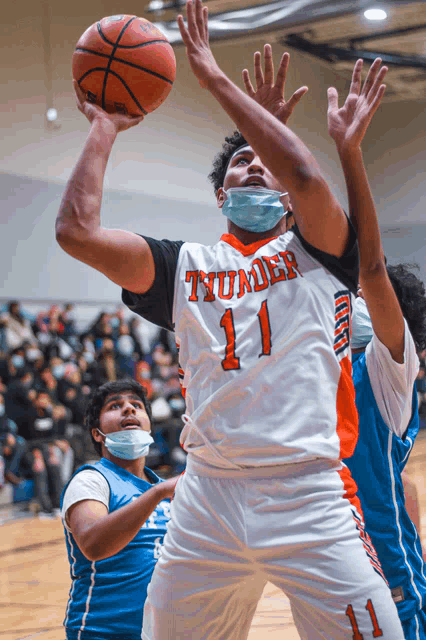 a basketball player with the number 11 on his jersey shoots a ball