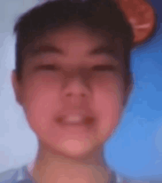 a close up of a young boy 's face with a blurred background .