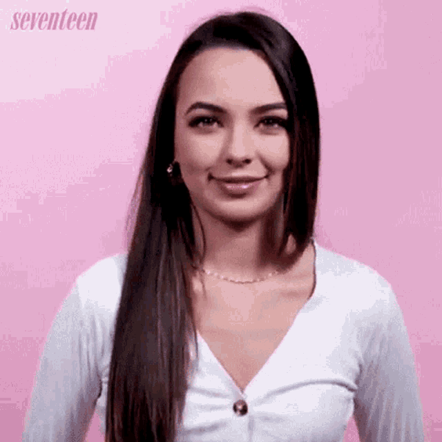 a woman is smiling in front of a pink background and the word seventeen is on the bottom