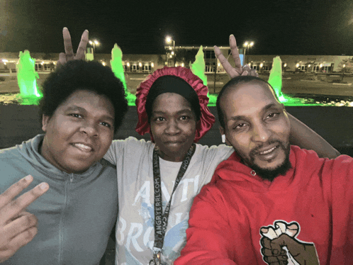 three people posing for a picture with one wearing a lanyard that says angry rebel.com