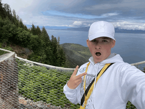 a man wearing a white hat and a white hoodie with the word ham on it takes a selfie