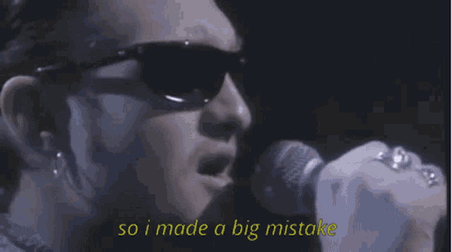 a man wearing sunglasses singing into a microphone with the words so i made a big mistake below him