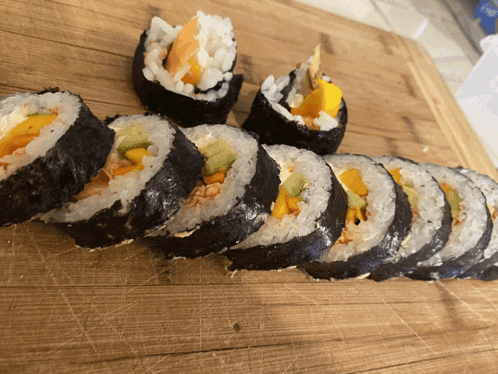 a row of sushi rolls on a wooden surface