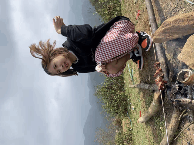 a girl in a plaid skirt is kneeling down in the dirt