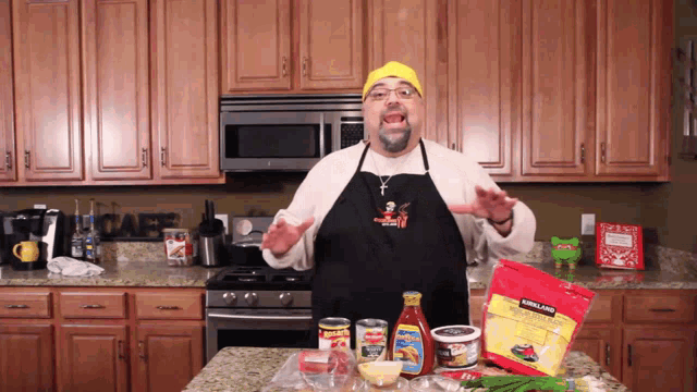 a man in an apron is standing in a kitchen with a bag of kirkland tortilla chips on the counter