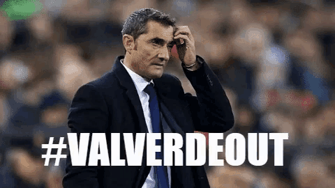 a man in a suit and tie stands in front of a #valverdeout banner