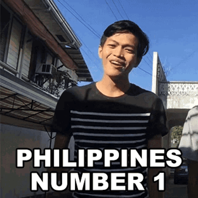 a man in a black and white striped shirt stands in front of a building with the words philippines number 1 above him