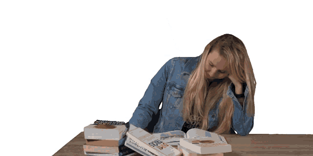 a woman sitting at a table with a stack of books including one that says ' a brief history '