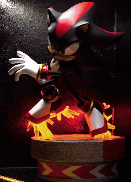 a statue of shadow the hedgehog is standing on a red and white circle