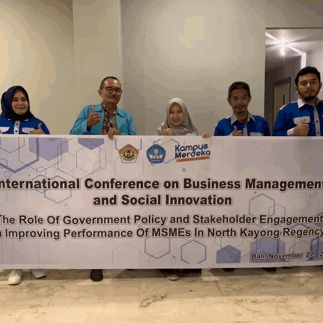 a group of people holding up a banner that says international conference on business management and social innovation