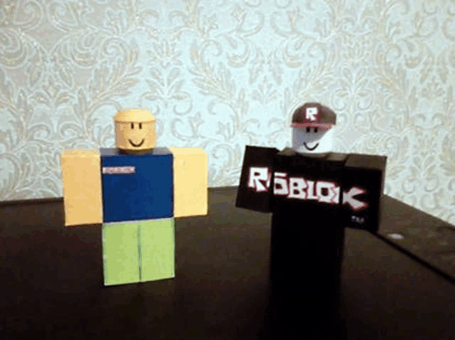 two toy roblox figures are standing next to each other