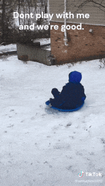 a child is sledding down a snow covered hill with the caption " dont play with me and we re good "