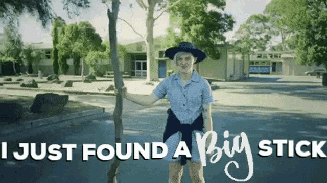 a woman standing next to a tree with the words " i just found a big stick " behind her