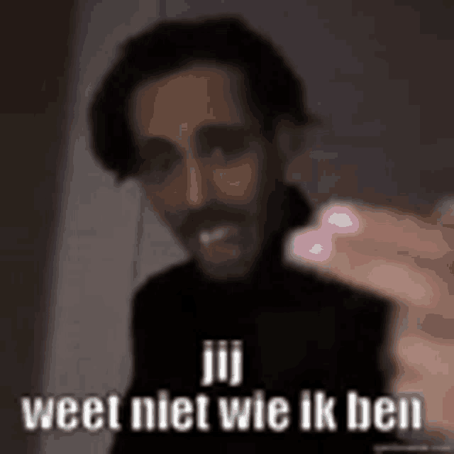 a blurry picture of a man holding a marshmallow with the words jij weet niet wie ik ben written below him .