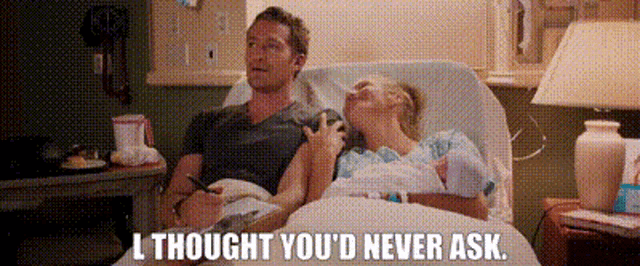 a man and a woman are laying in a hospital bed and the man is saying i thought you 'd never ask .