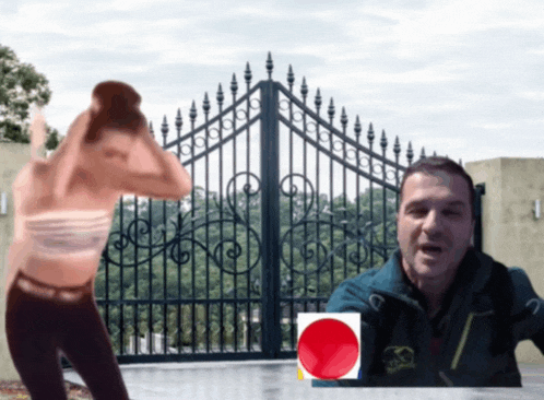 a man and a woman standing in front of a gate