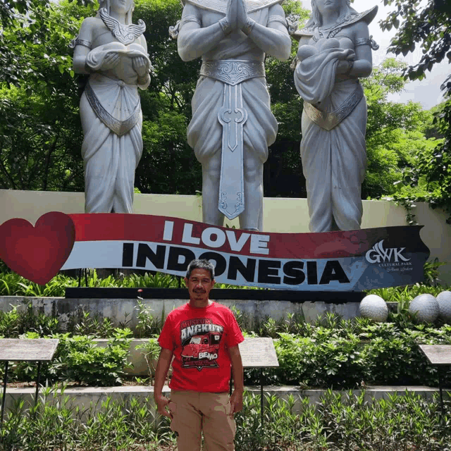 a man stands in front of a sign that says " i love indonesia "