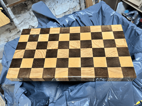 a wooden cutting board with a checkered design on it