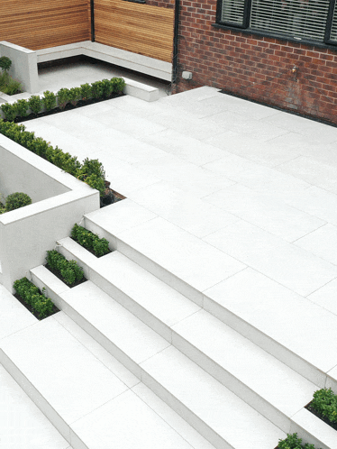 a brick building with a white tiled patio and stairs