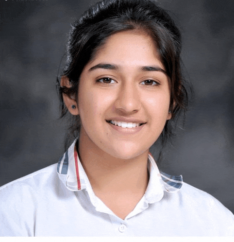 a young woman wearing a white shirt with a plaid collar smiles for the camera