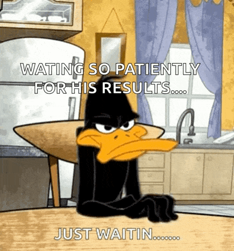 daffy duck is sitting at a table in a kitchen waiting patiently for his results