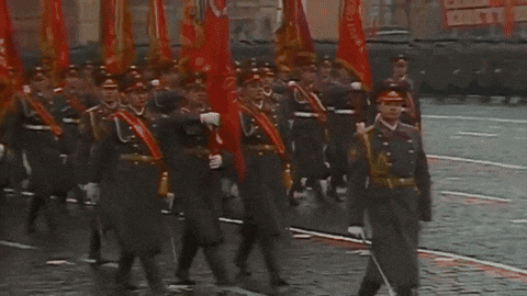 a group of soldiers marching down a street with red flags in front of a sign that says " cccp "