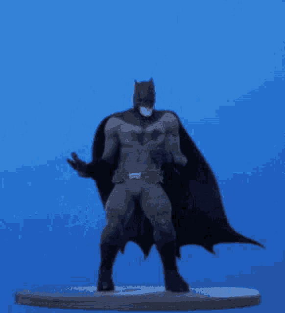 a batman figure is dancing on a blue background