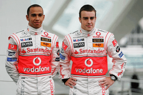 two men wearing santander and vodafone jackets pose for a picture