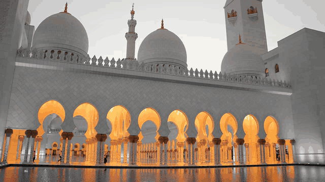 a white mosque with arches and columns and a large dome