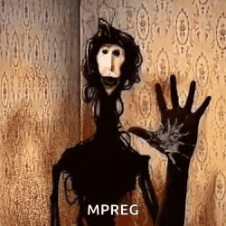 a scary puppet is standing in front of a wall and waving at the camera .