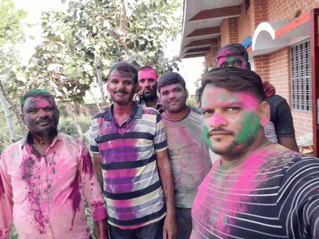 a group of men with their faces painted with pink and green powder