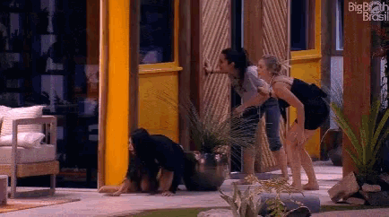 a group of women are standing in front of a building with the words big brother brasil written on it .