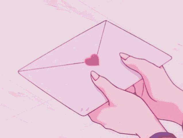 a person is holding a pink envelope with a pink heart on it .