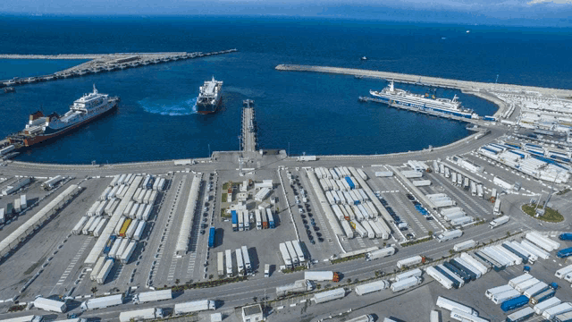 an aerial view of a harbor with trucks and ships in it