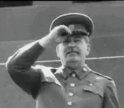 a man in a military uniform is adjusting his hat .