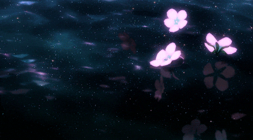 a few pink flowers are floating in the water at night