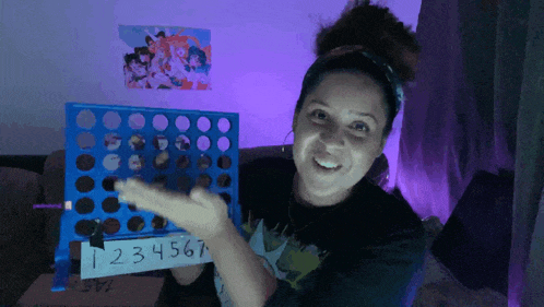 a woman is holding a connect four board with the numbers 1234567 on it