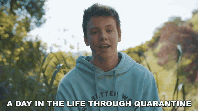 a young man wearing a hoodie with the words " a day in the life through quarantine " above him