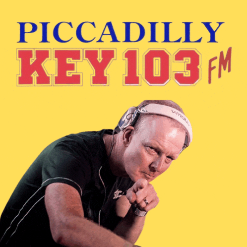 a man wearing headphones and a headband with the words piccadilly key 103 fm above him