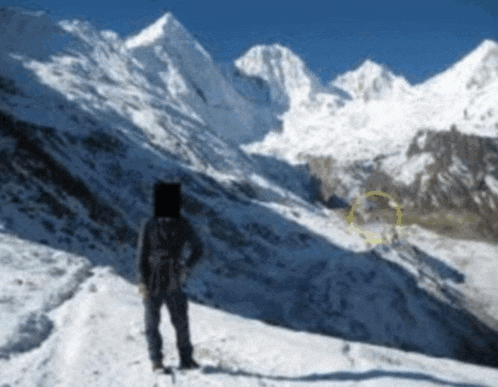 a person standing on a snowy mountain with a yellow circle in the middle