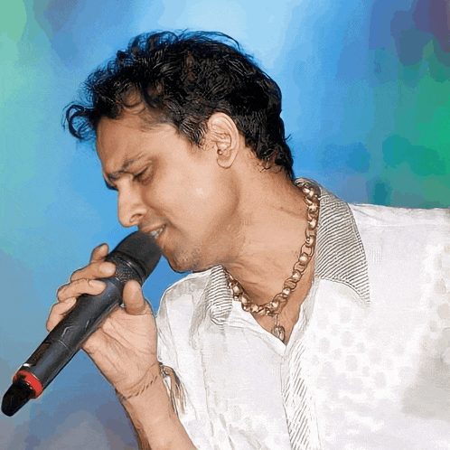 a man singing into a microphone with a blue background