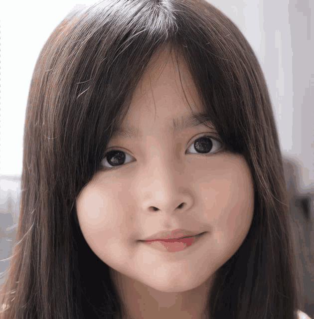 a close up of a little girl 's face with long hair